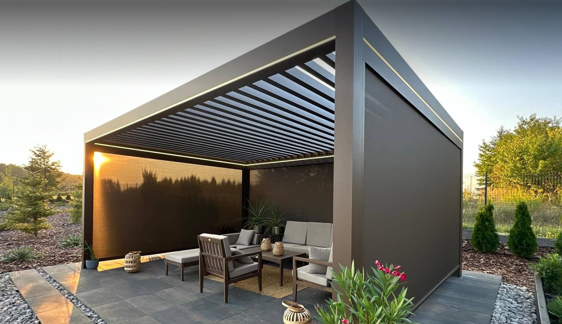 Moderne Pergola mit Lamellendach über einer möblierten Terrasse im Garten bei Sonnenuntergang.